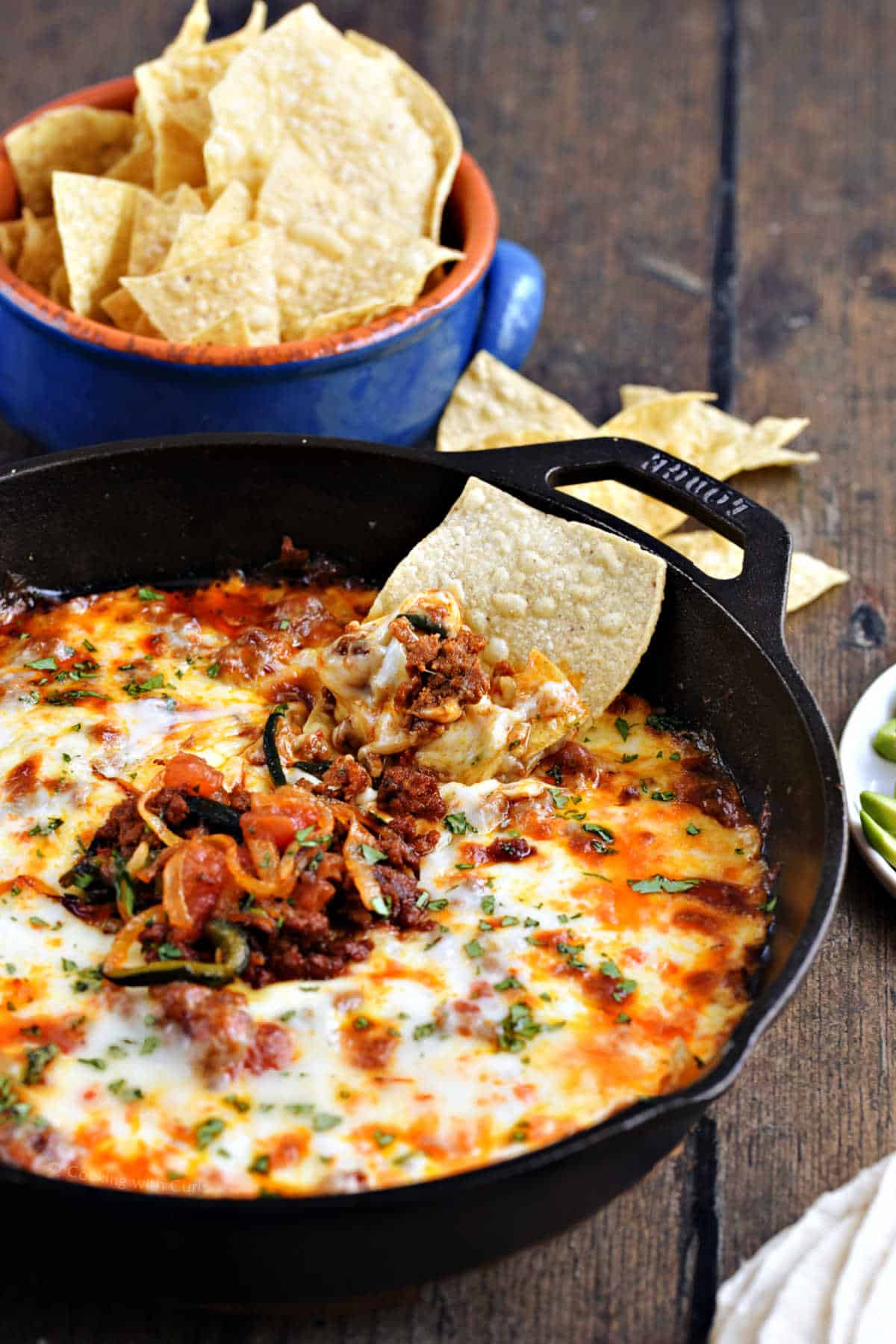 Queso Fundido Mexican melted cheese in a skillet with tortilla chips.