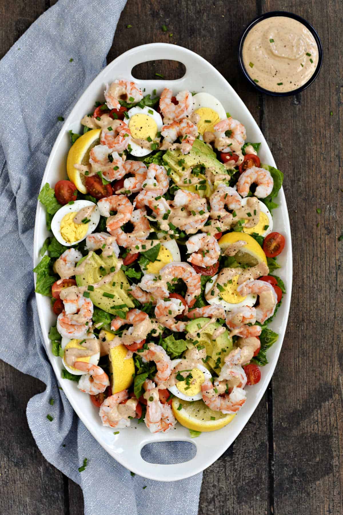 Shrimp salad with hard-boiled eggs and avocado on a platter.