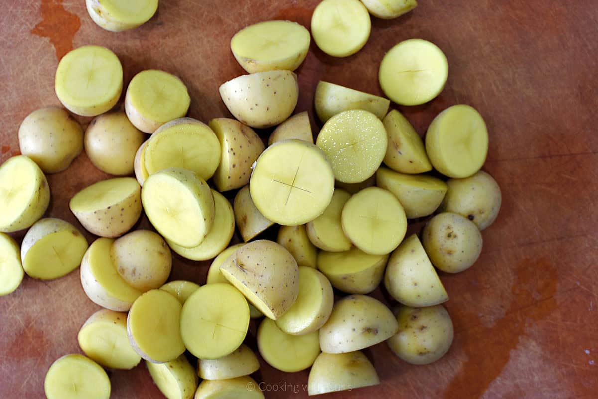 Baby gold potatoes cut in half on cutting board.