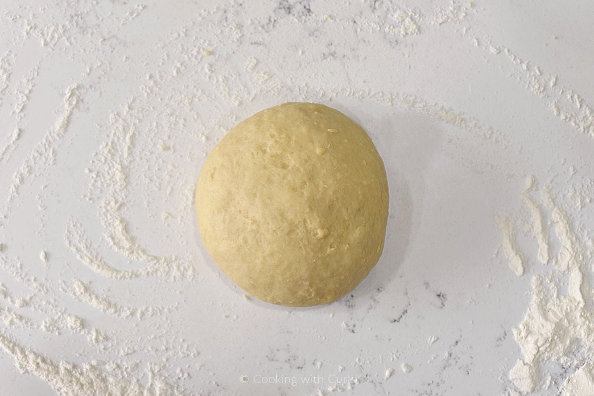 Ball of dough on floured work surface.