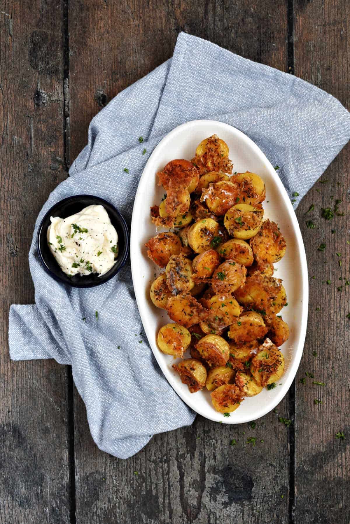 Parmesan roasted potatoes on a serving platter with a side of garlic aioli.