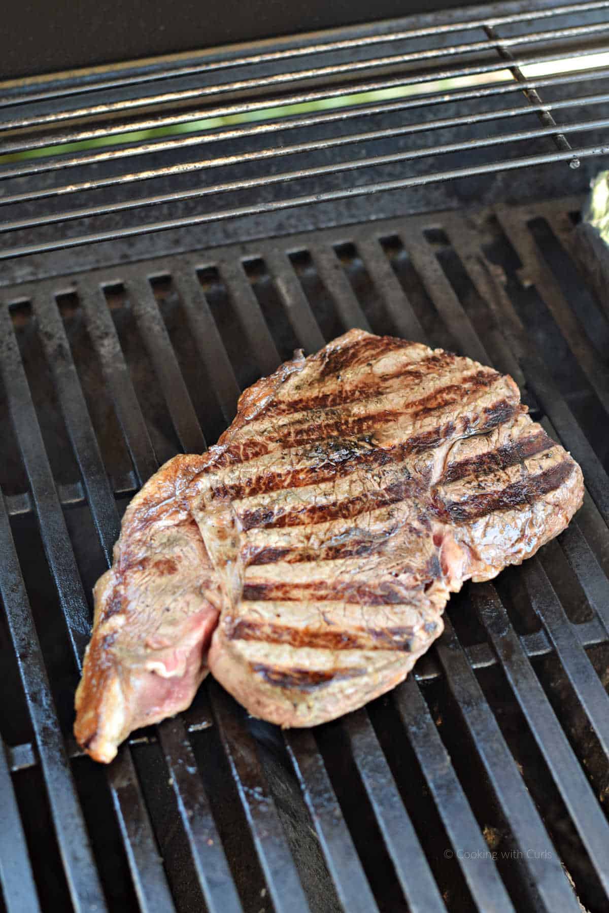 Grilled sirloin steak on the grill.