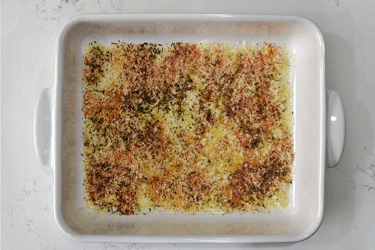 Parmesan cheese, seasonings, and olive oil in a baking dish.