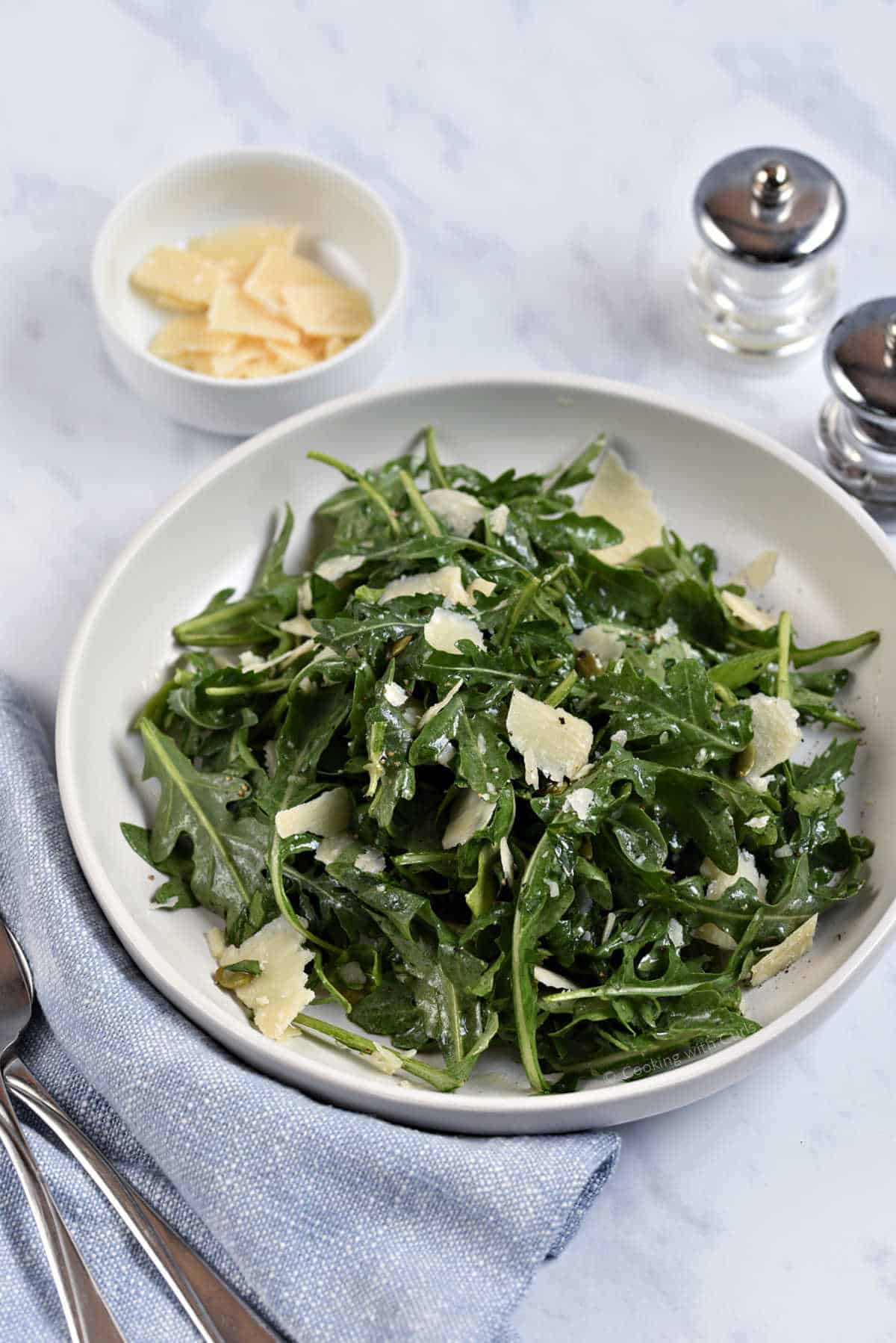 Arugula salad tossed with shaved parmesan cheese, herbs, and pumpkin seeds.