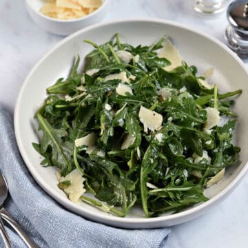 Arugula salad tossed with shaved parmesan cheese, herbs, and pumpkin seeds.