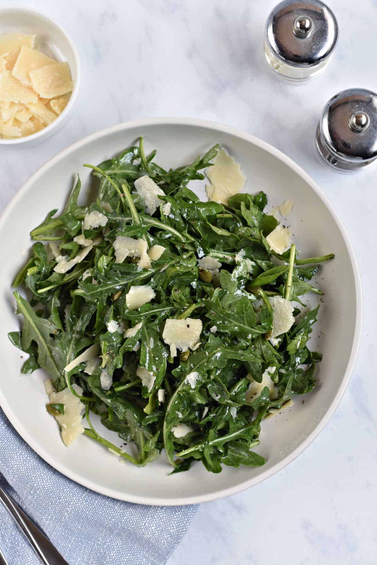 Arugula salad tossed with lemon dressing, shaved parmesan, and pumpkin seeds.