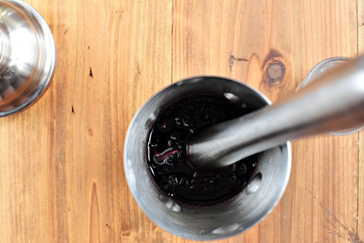 Blackberries and simple syrup in a cocktail shaker.