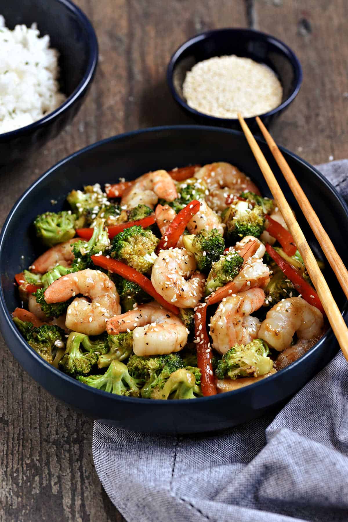 Stir fry shrimp, broccoli, and red pepper strips in a bowl.