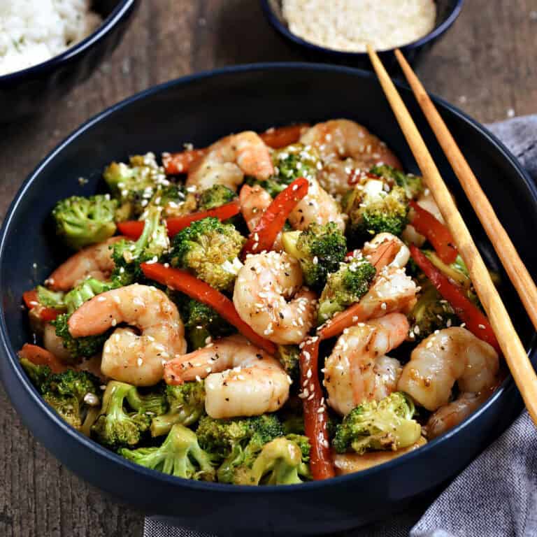 Stir fry shrimp, broccoli, and red pepper strips in a bowl.