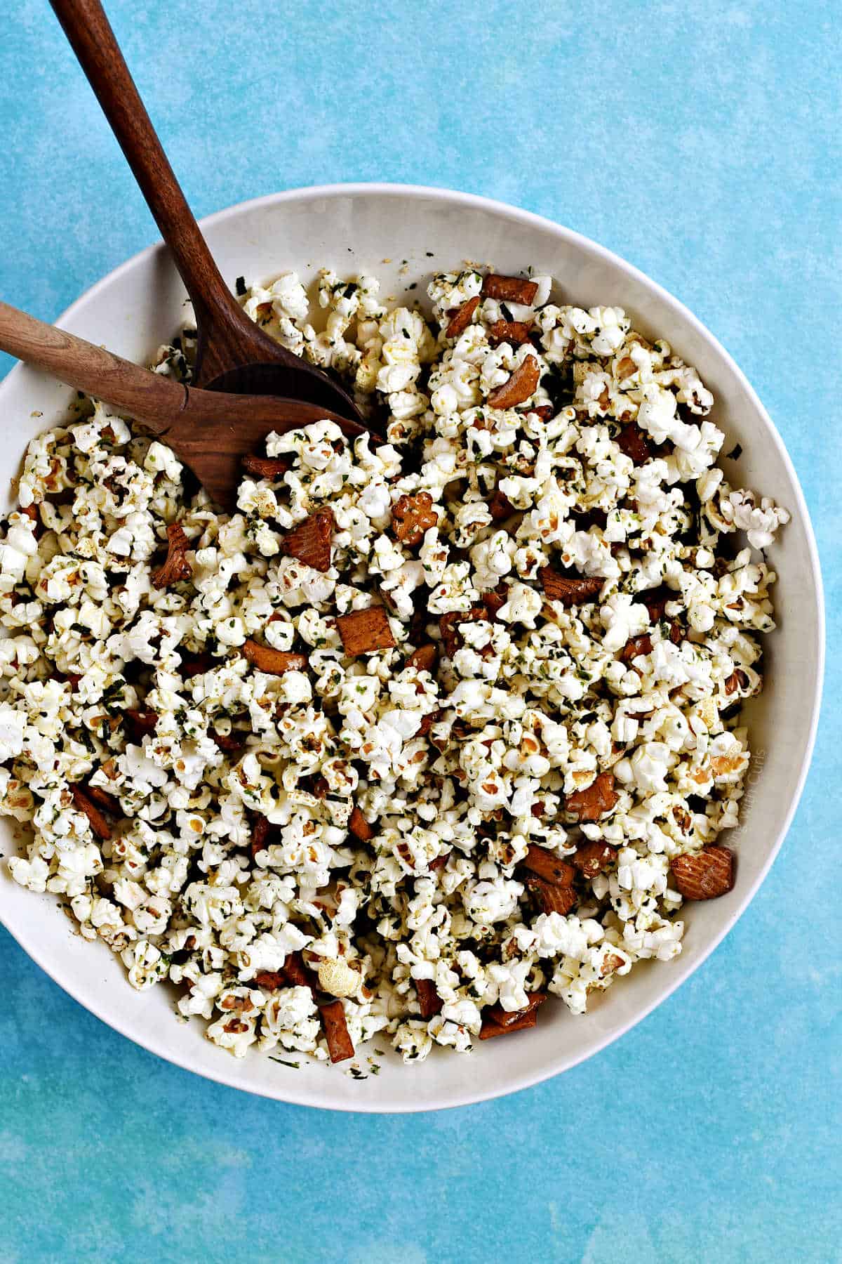 A large bowl of popcorn mixed with seaweed and sesame seasoning and rice crackers.