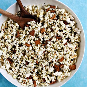 A large bowl of popcorn mixed with seaweed and sesame seasoning and rice crackers.