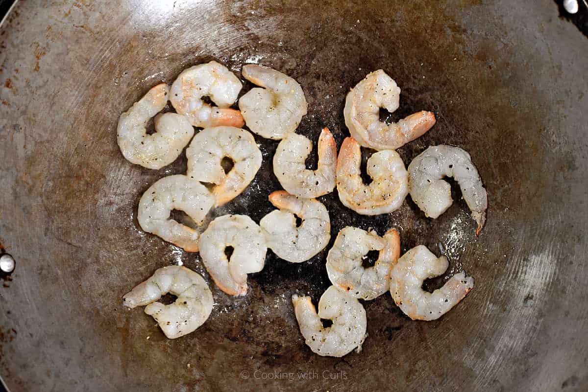 Raw shrimp cooking in a wok.