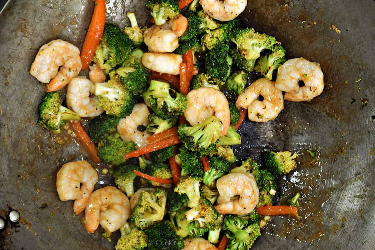 Shrimp and vegetable stir fry in wok.