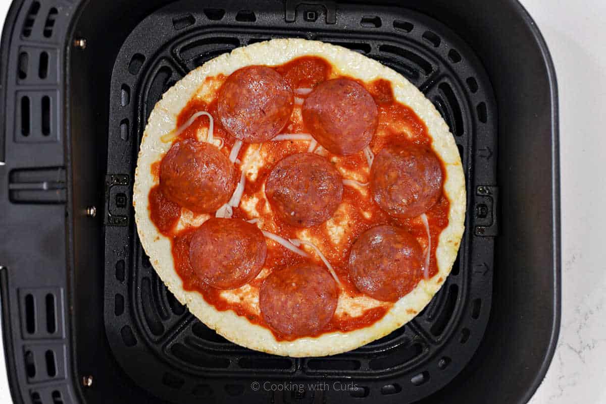 Tortilla with pizza sauce and pepperoni slices.