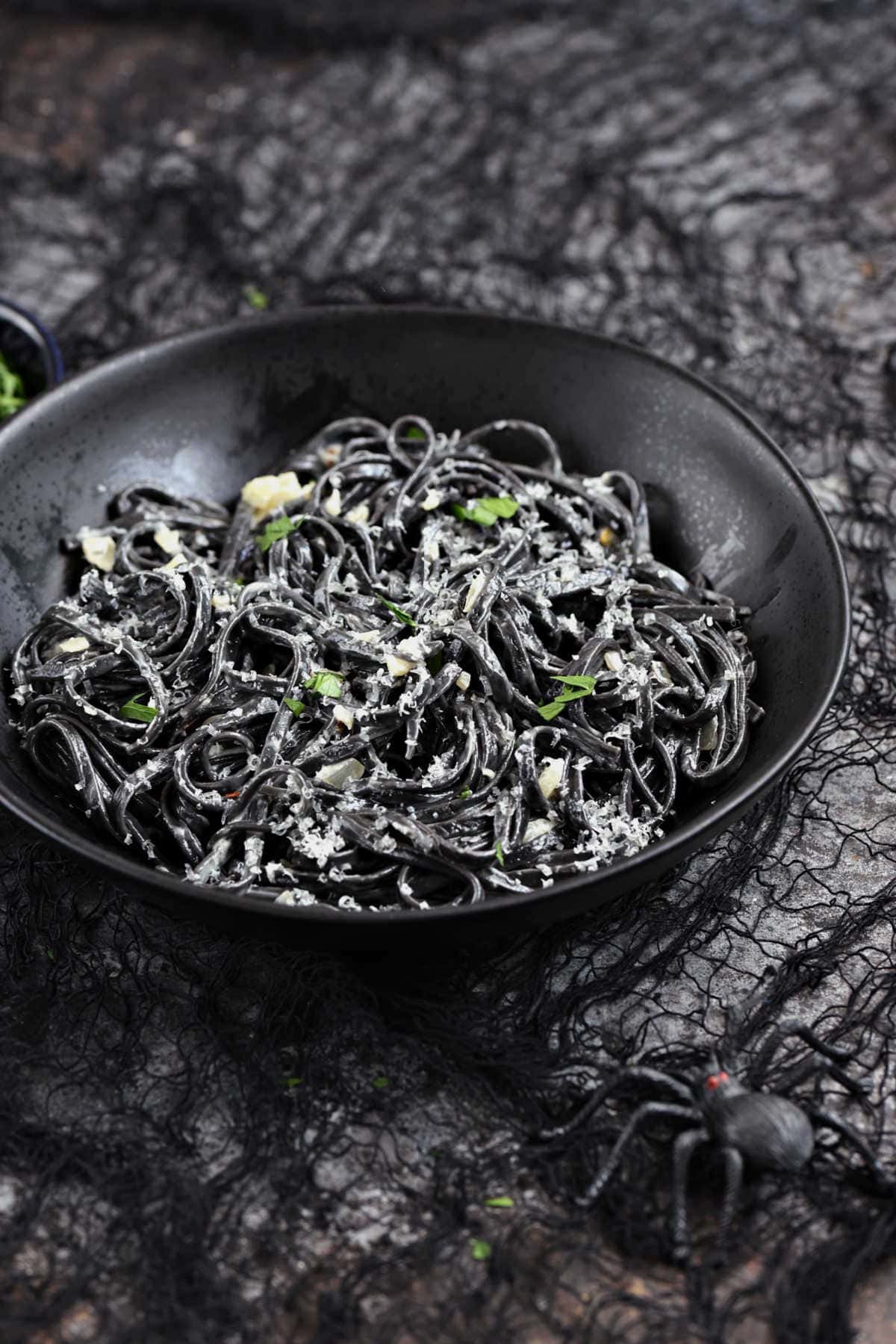 Black squid ink pasta in a creamy sauce topped with parmesan cheese.