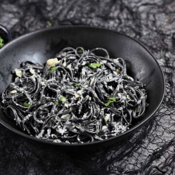 Black squid ink pasta in a creamy sauce topped with parmesan cheese.