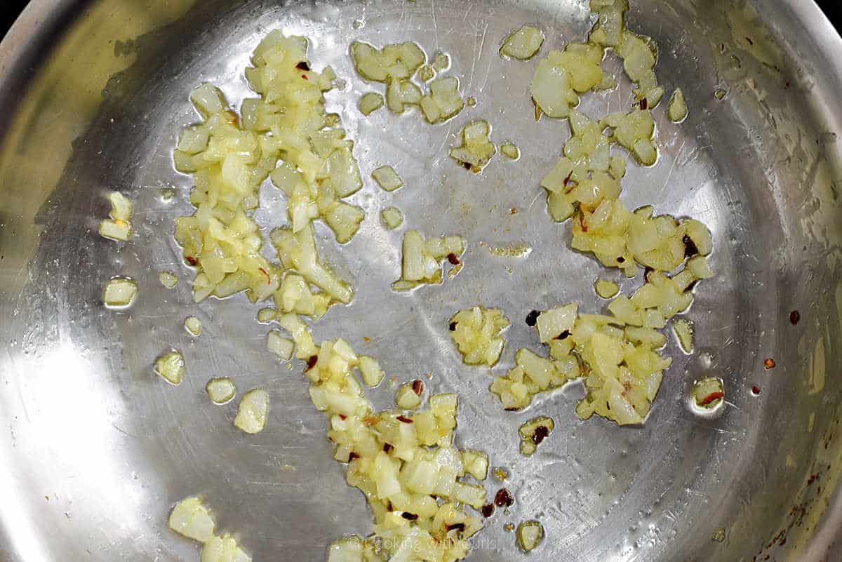 Diced onion, garlic, and pepper flakes in a skillet.