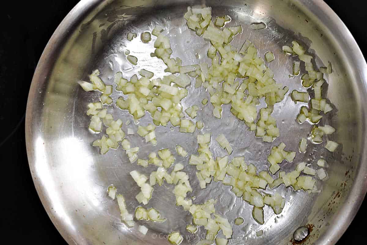 Diced onion cooking in a skillet.