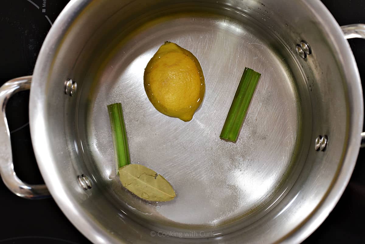 Lemon, celery, bay leaf, salt and water in a large pot.