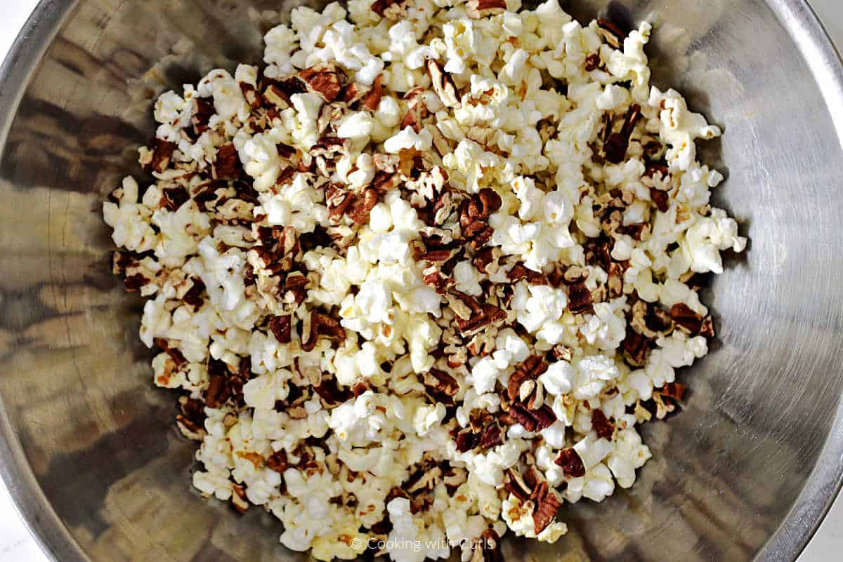 Popped popcorn and toasted pecan pieces in a large bowl.