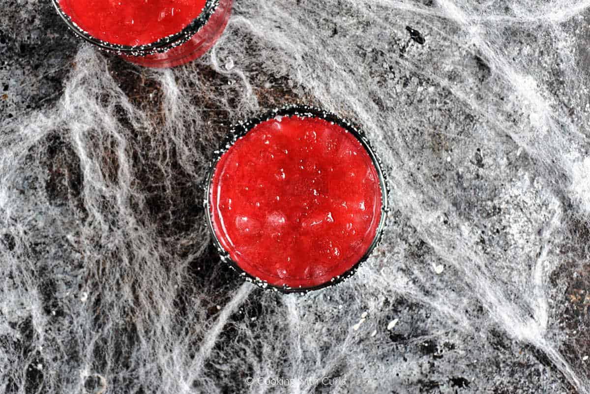 Red cocktail in two ice filled glasses.