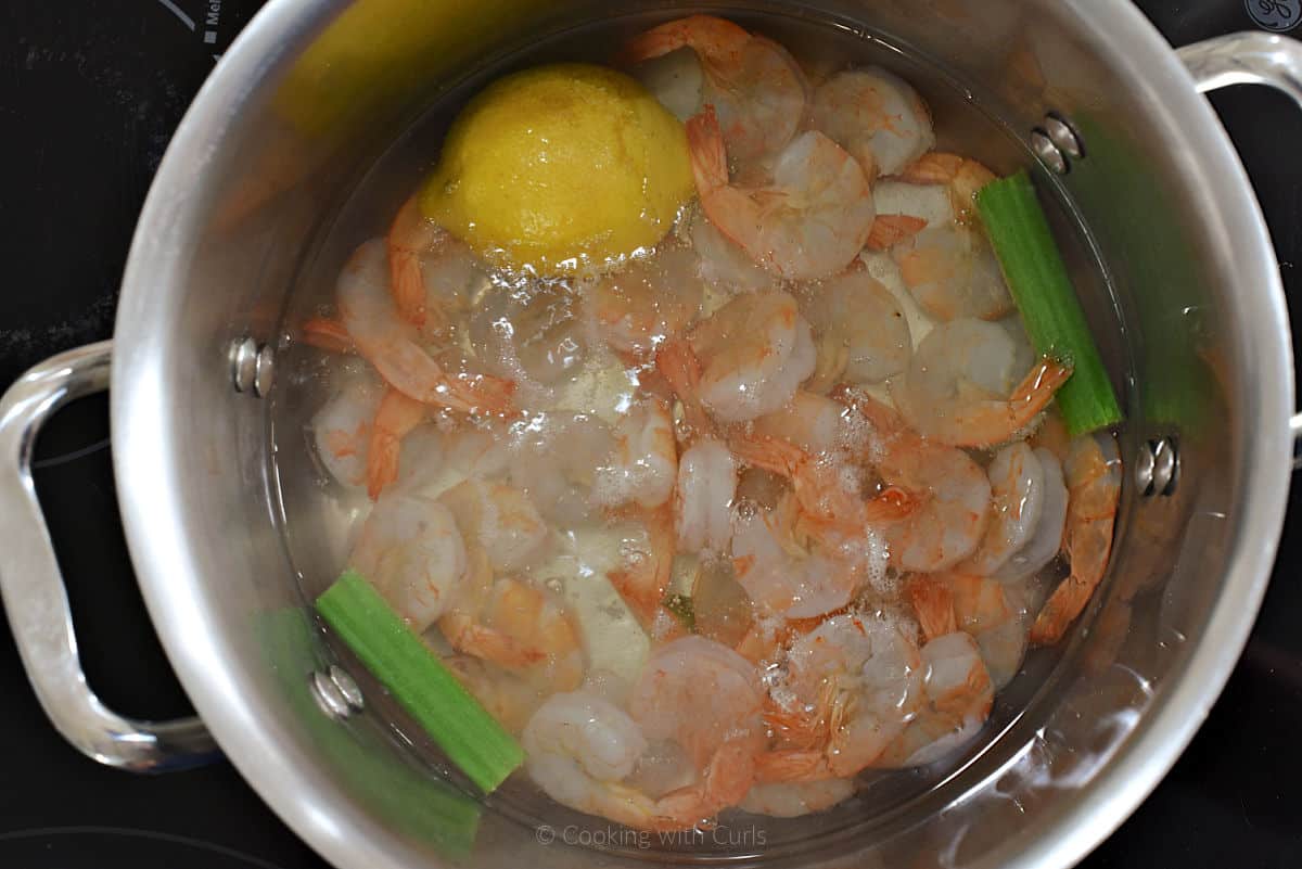 Shrimp, celery and lemon boiling in water.