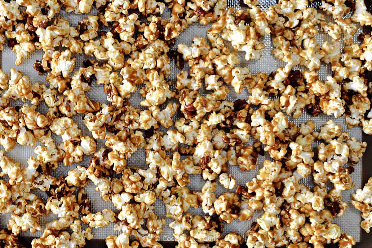 Sticky bun popcorn spread on baking sheet.