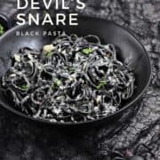 Black squid ink pasta in a creamy sauce topped with parmesan cheese with title graphic across the top.