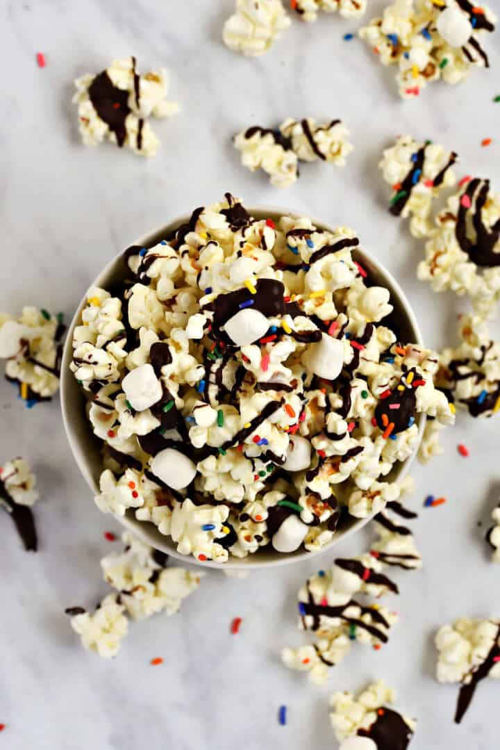 Dark chocolate covered popcorn with sprinkles.