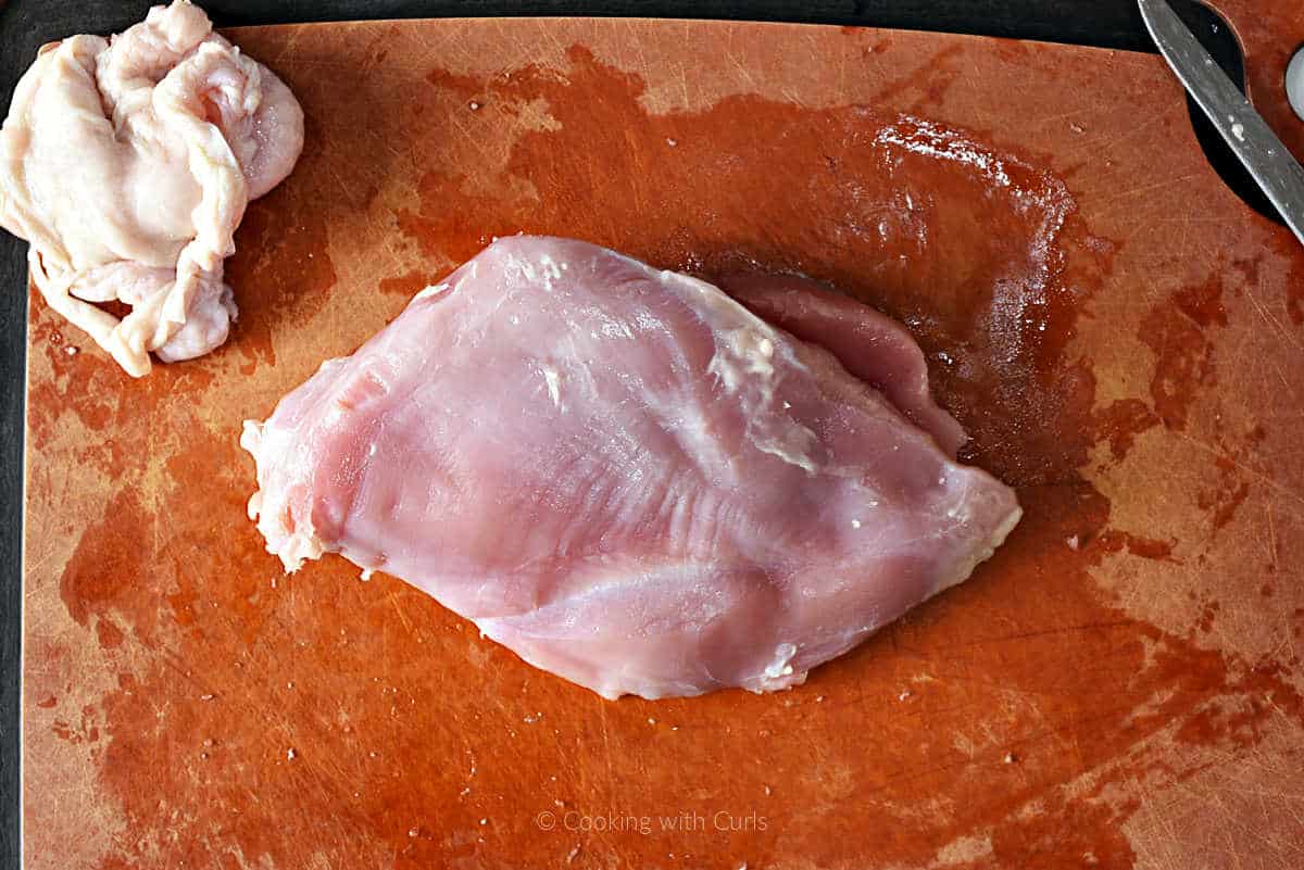 Boneless, skinless turkey breast on cutting board.