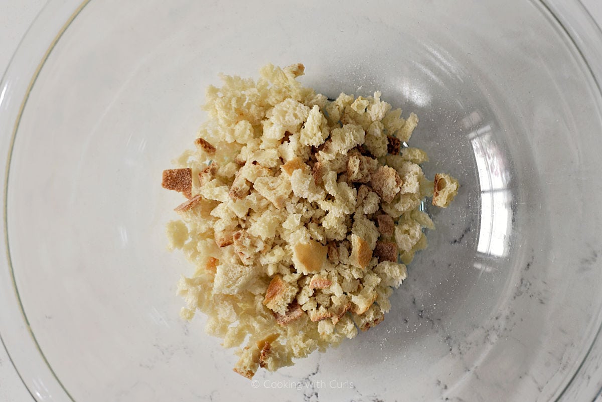 Dried bread cubes in glass mixing bowl.