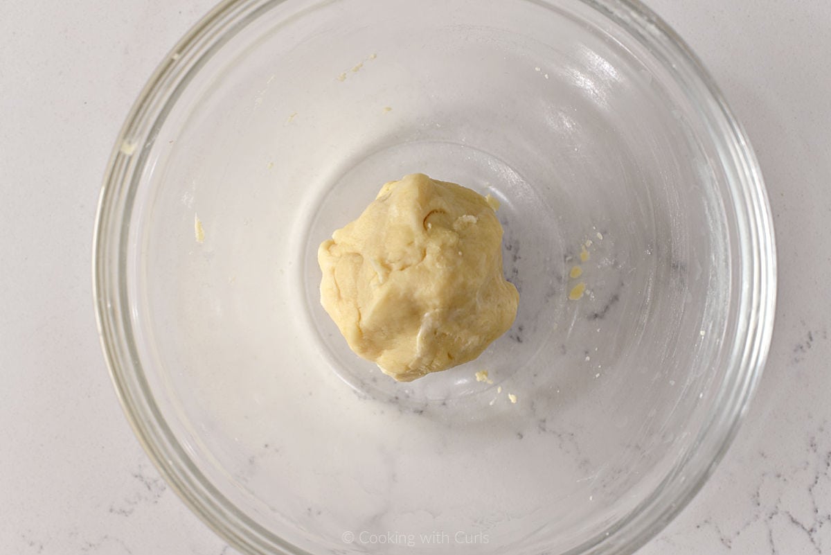 Ball of pie crust dough in a mixing bowl.