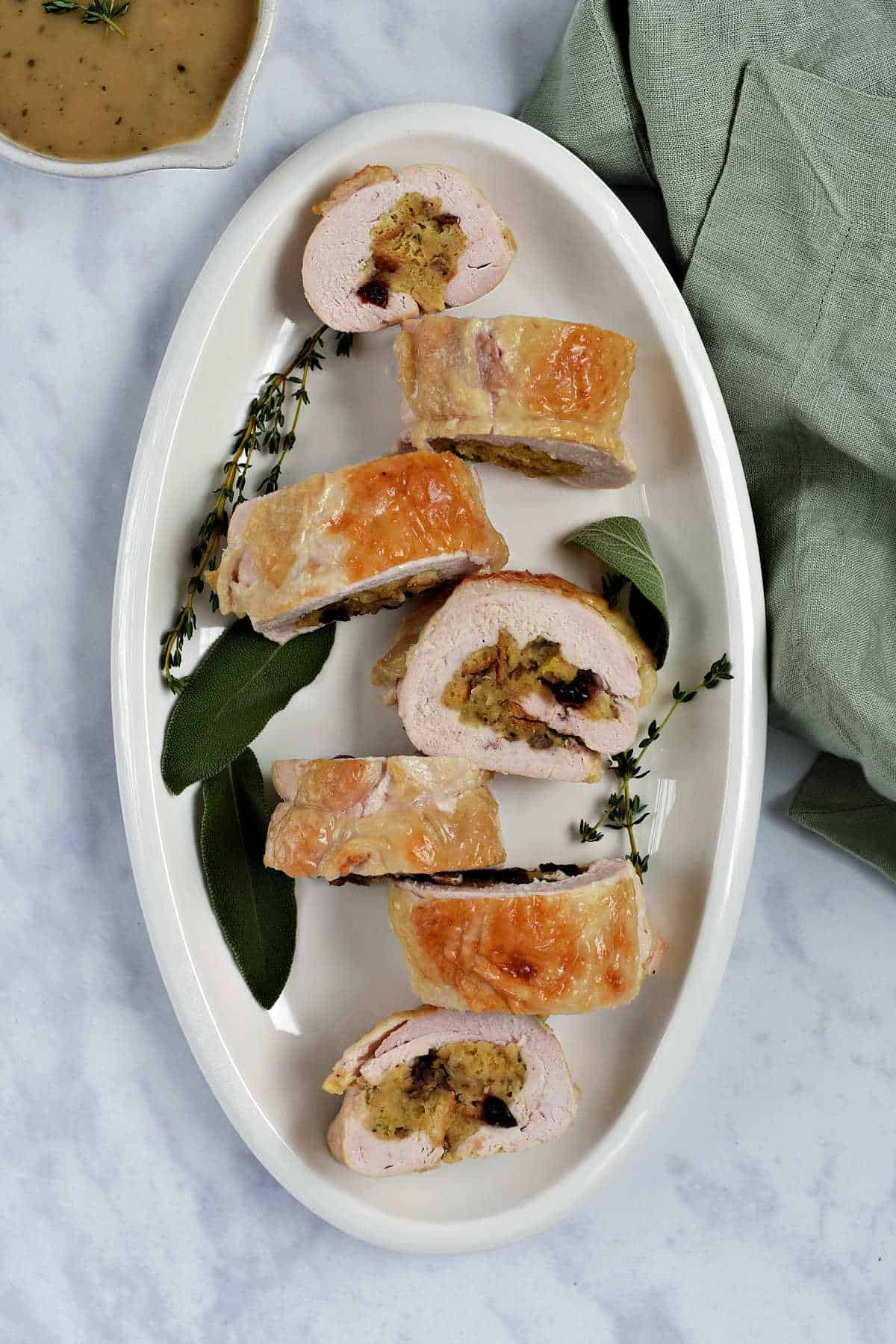 Stuffed turkey breast in seven slices on a serving platter.