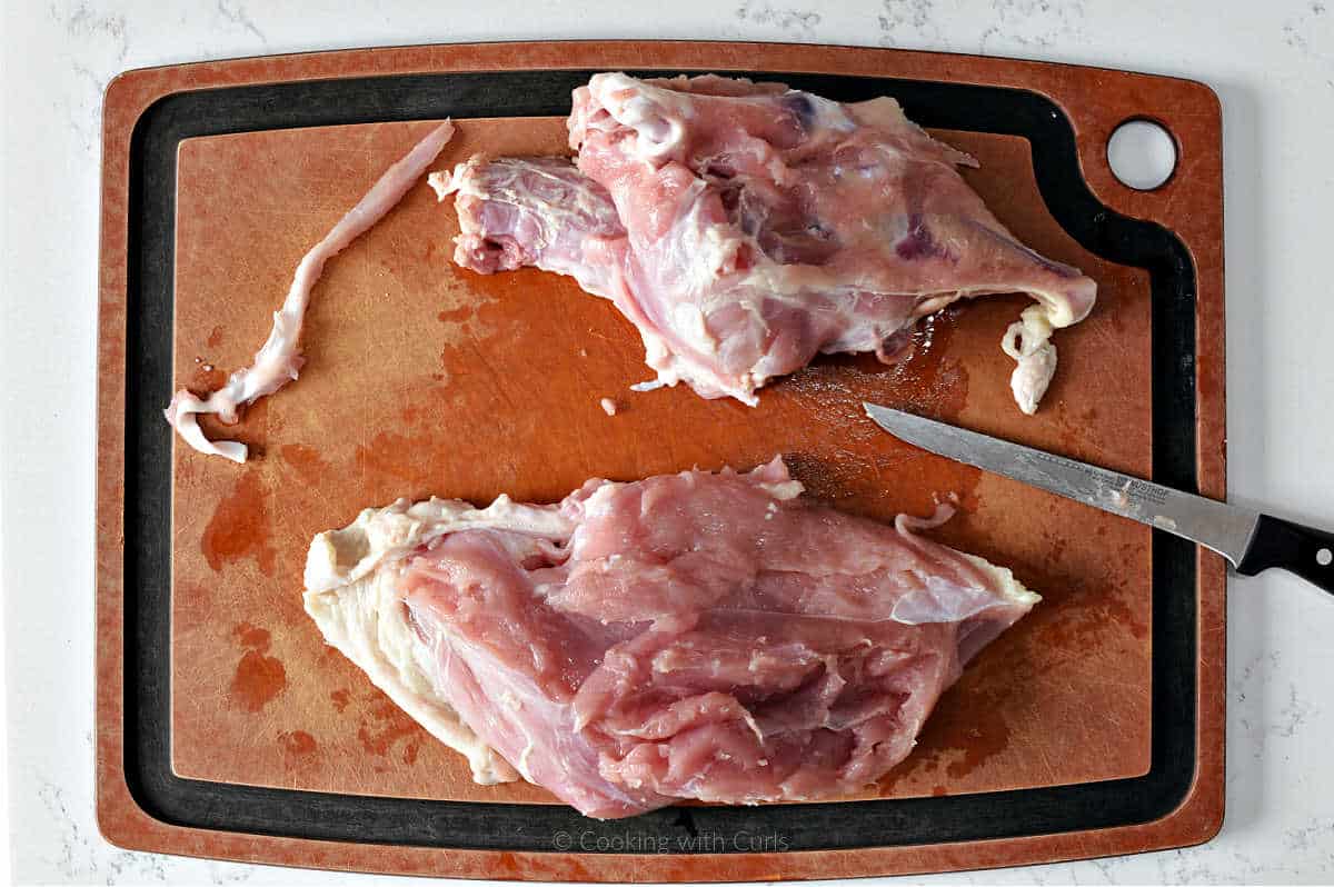 Turkey breast removed from the bone on cutting board.