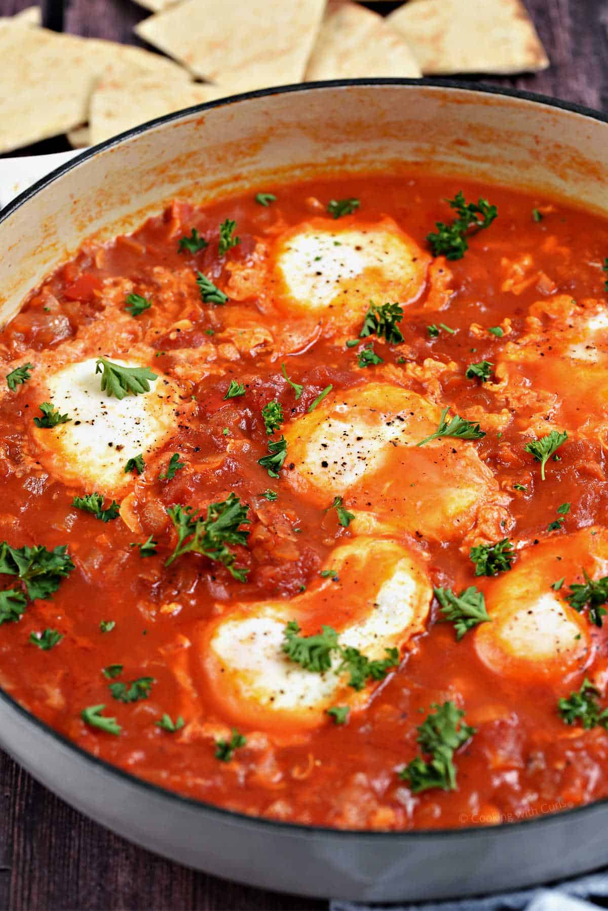 Eggs poached in tomato sauce in a skillet.