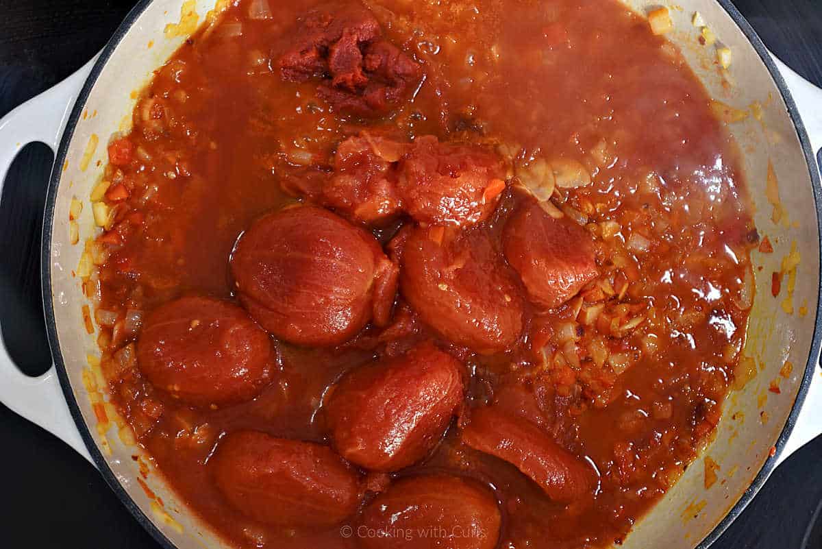 Whole, peeled tomatoes and tomato paste in skillet.