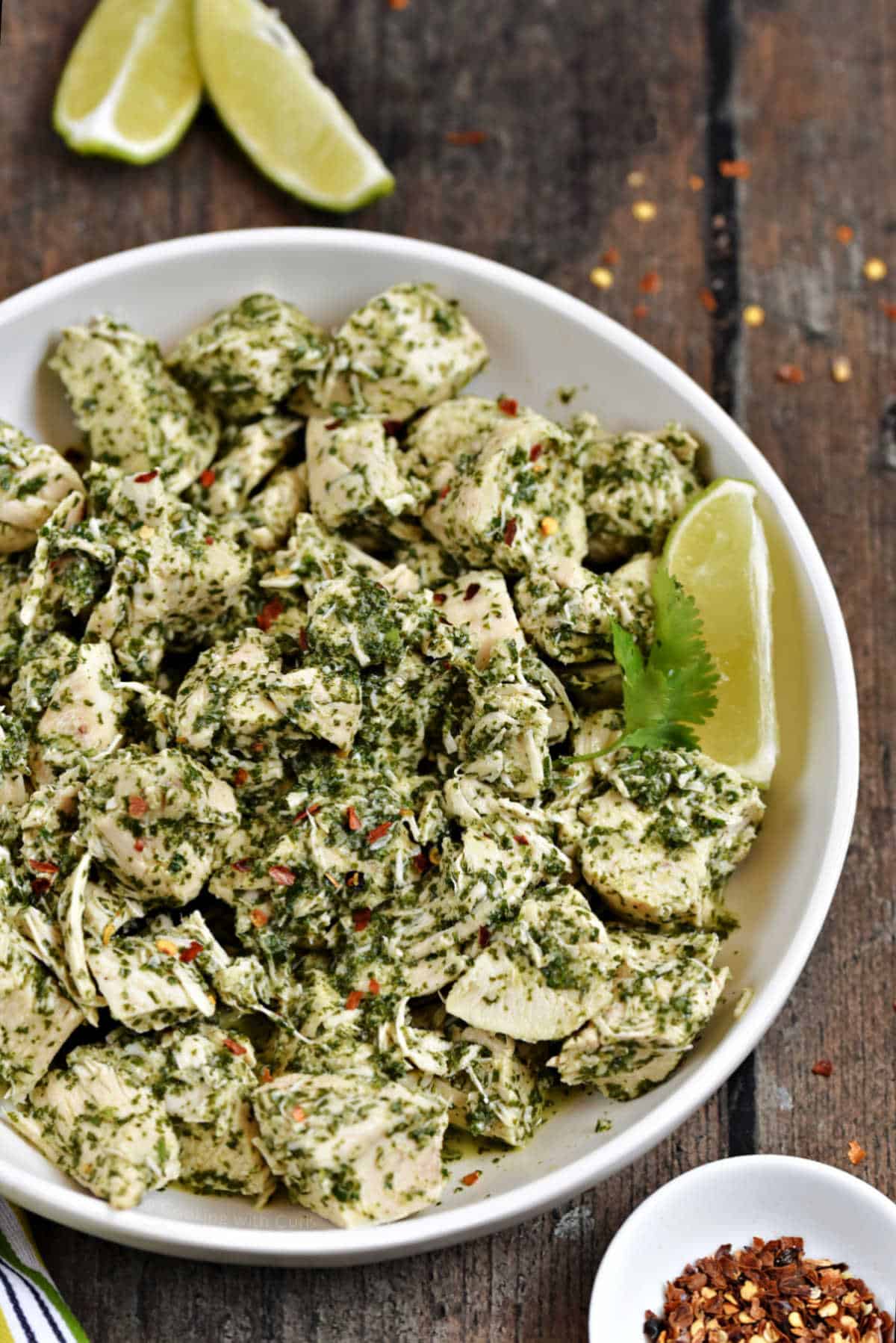 Chunks of chicken mixed with chimichurri sauce in a serving bowl.