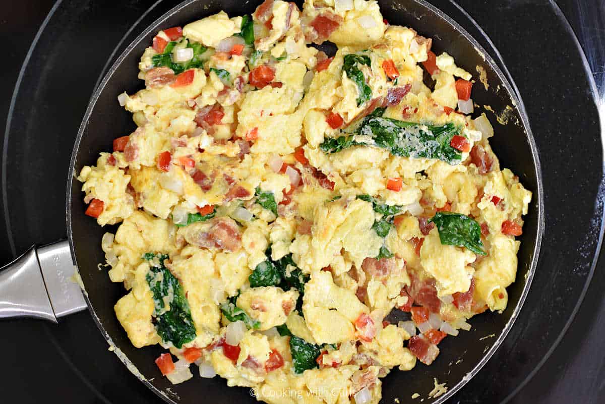 Scrambled eggs with red pepper, onion, and spinach in small skillet.