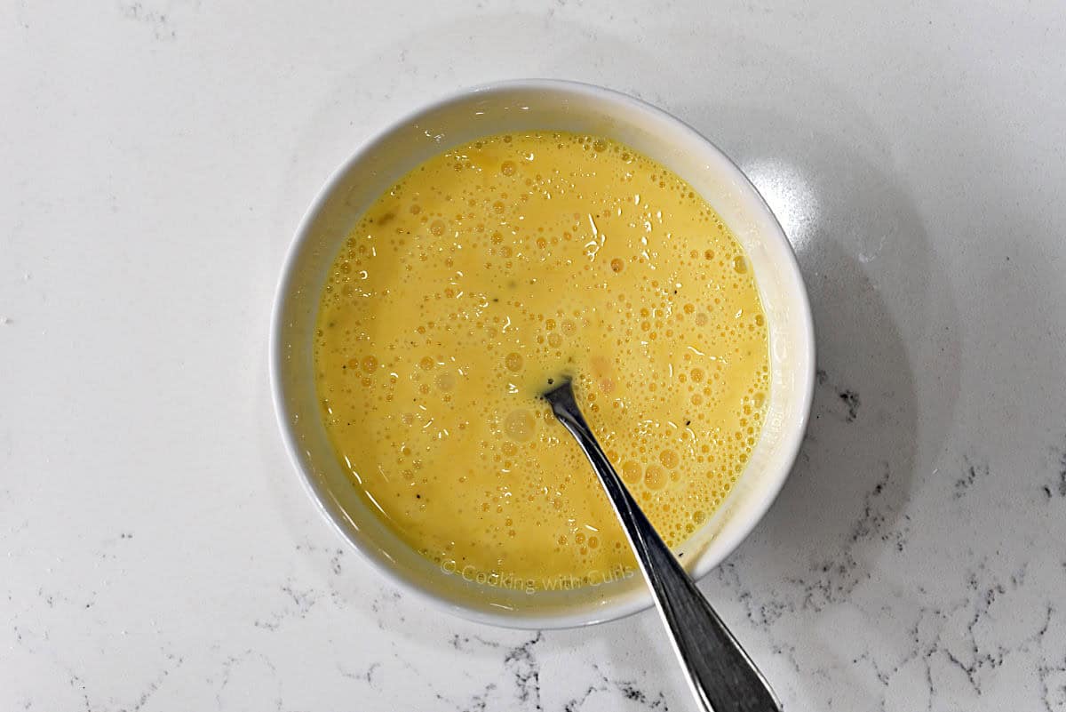 Eggs and cream scrambled in a small bowl.