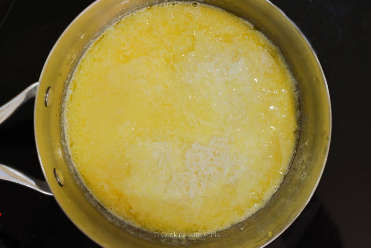 Melted butter, heavy cream, and grated parmesan cheese in sauce pan.