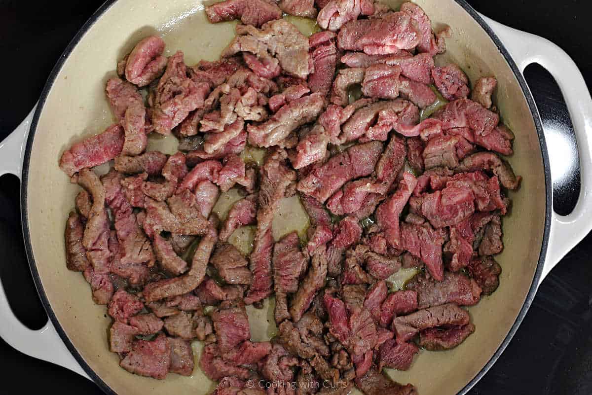 Browned sliced beef in skillet.