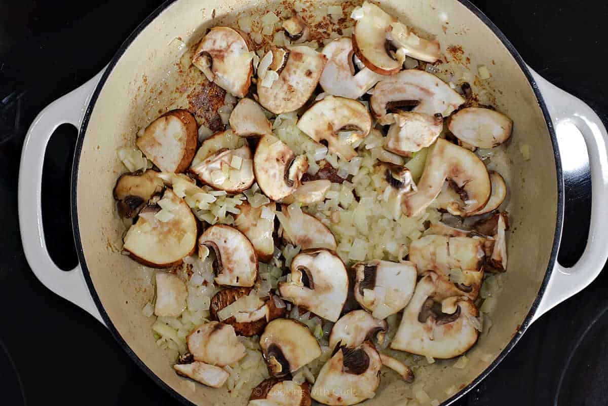 Sliced mushrooms and diced onion in skillet.