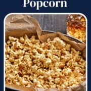 Buffalo popcorn in a parchment lined metal basket with a cocktail in the background and title graphic across the top.