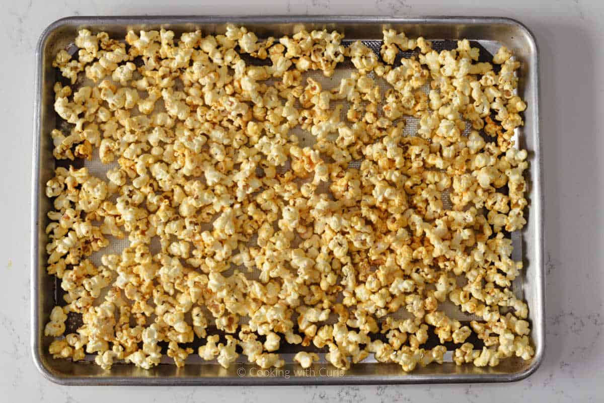 Buffalo seasoned popcorn on baking sheet.