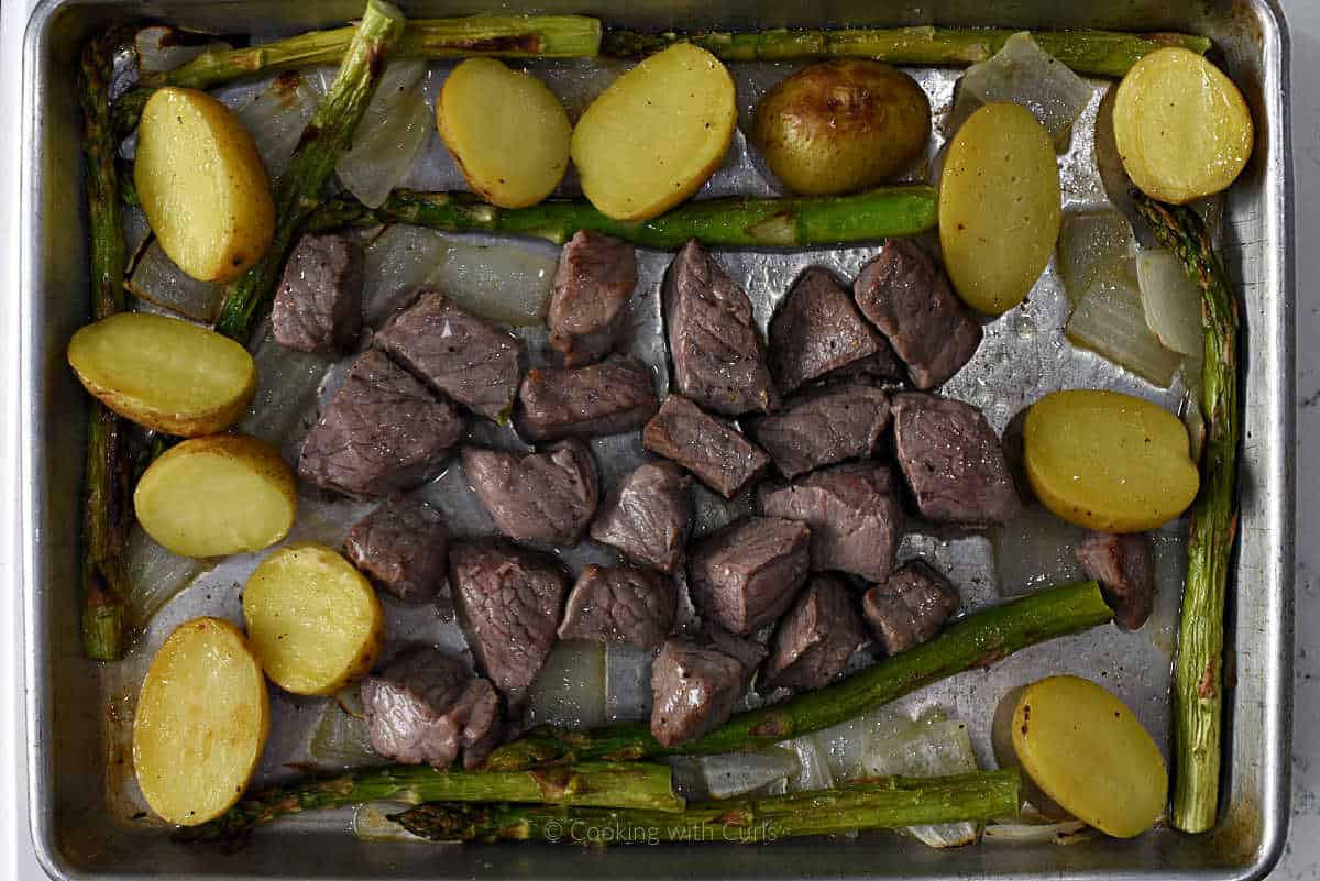 Roasted steak bites, asparagus, and potatoes on sheet pan.