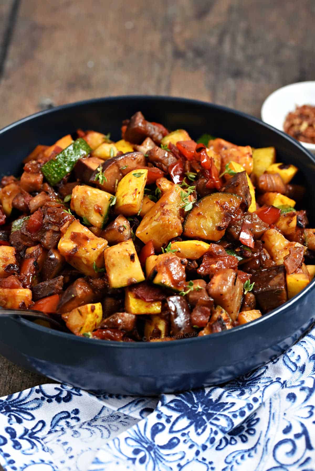 Cooked eggplant, zucchini, squash, tomatoes, and red pepper in a bowl.