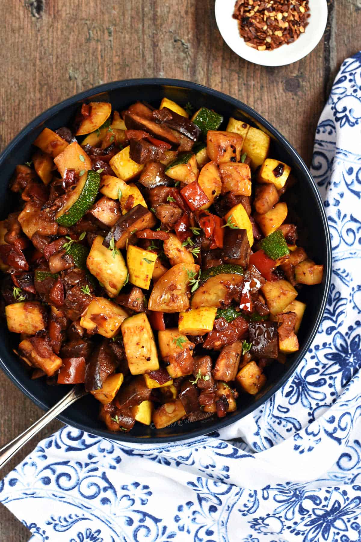 Stewed zucchini, eggplant, squash, red pepper, and tomatoes in a bowl.