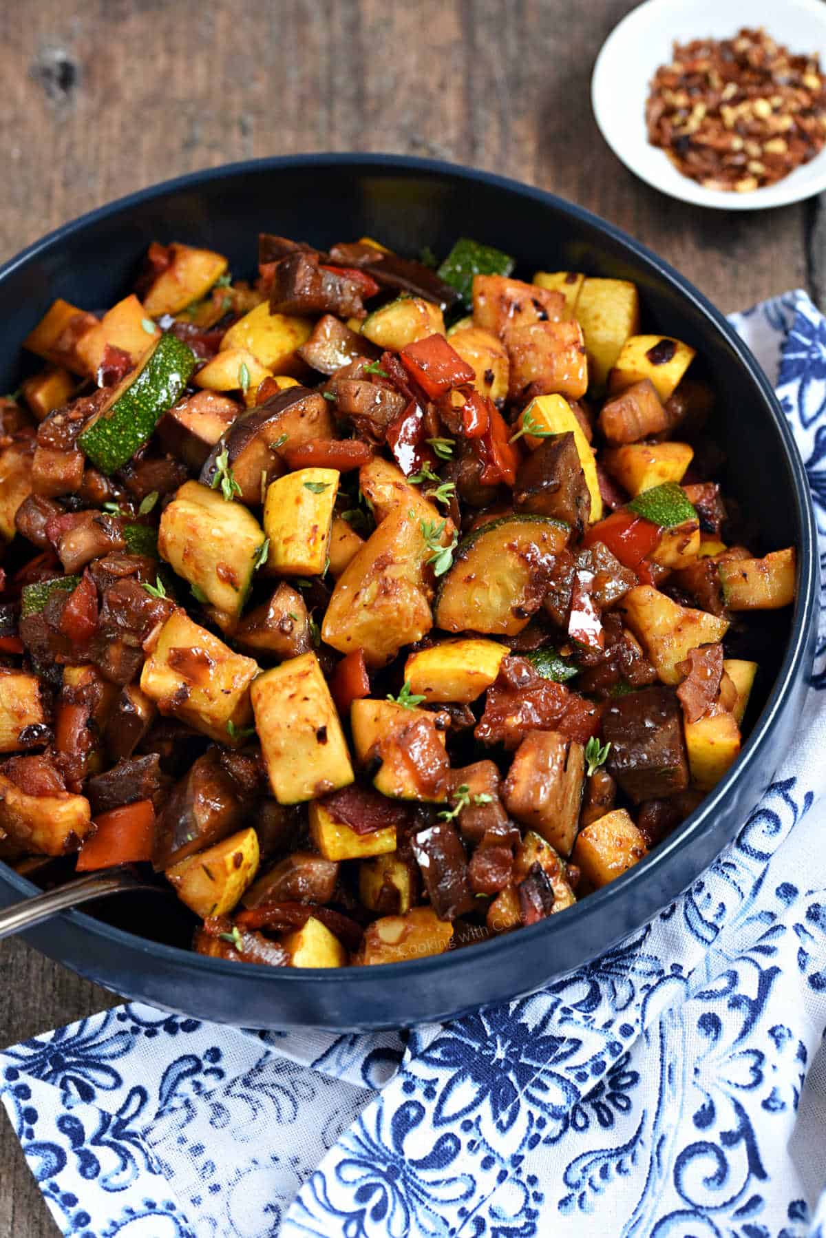 Stewed eggplant, squash, tomato, and bell pepper in a bowl.